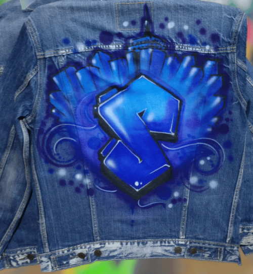 Custom airbrushed jean jacket with blue, purple, and teal graffiti cityscape design and "S" letter